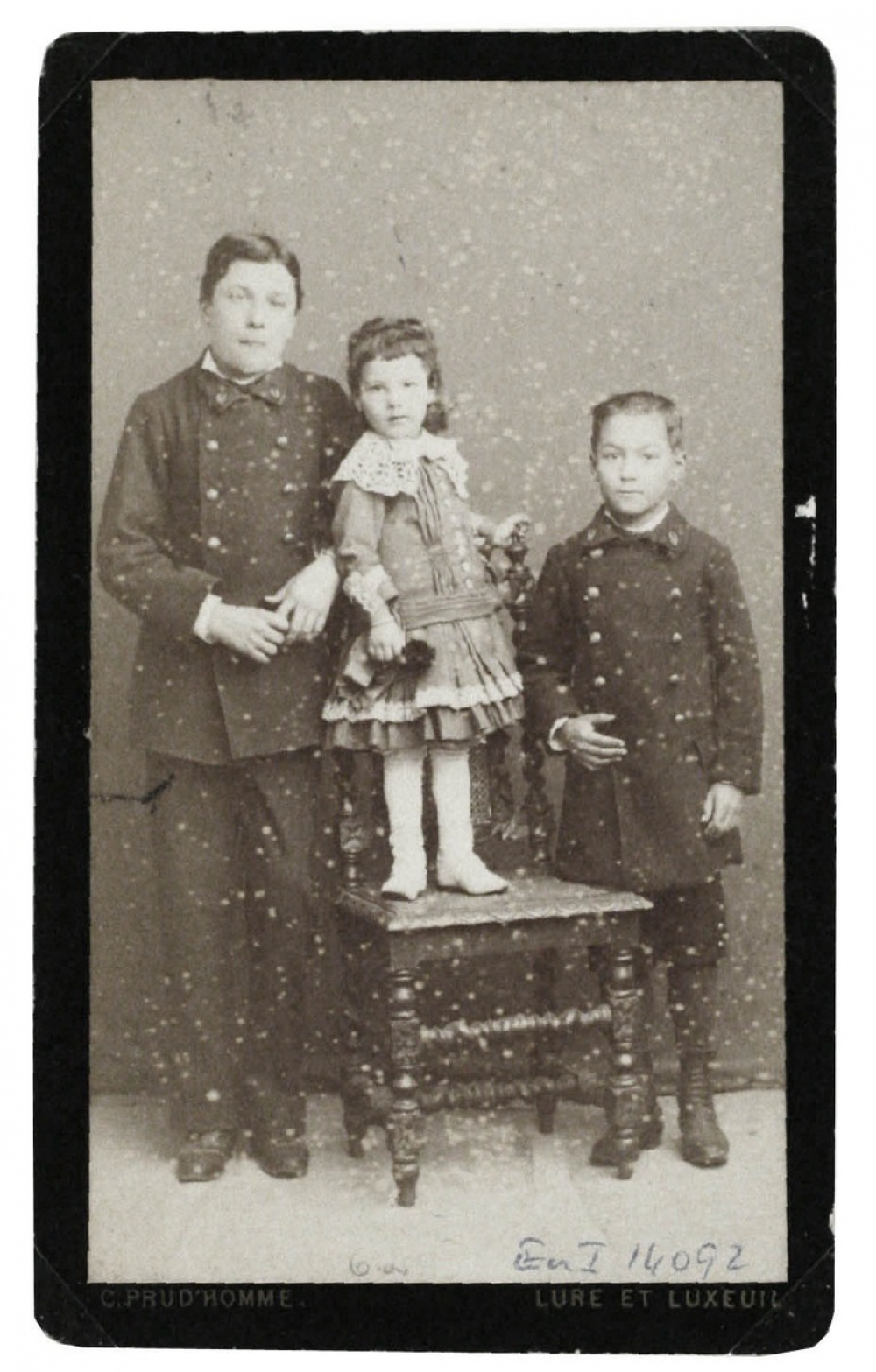 Deux garçons en costume et une fillette. 