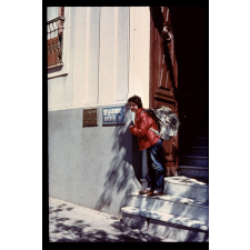 Femme posant à côté d'une panneau auberge de jeunesse