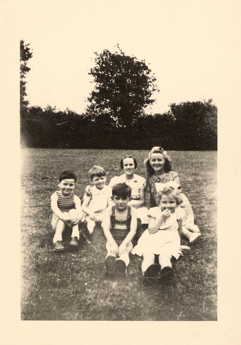 Portrait d'un groupe d'enfants assis dans l'herbe