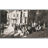 Groupes d'élèves assis sur une pelouse devant un bâtiment.