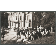 Groupes d'élèves assis sur une pelouse devant un bâtiment.