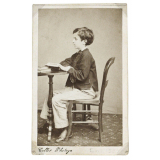 Jeune garçon assis, vu de profil. 