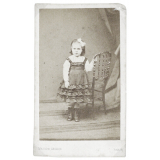 Petite fille s'appuyant à une chaise. 