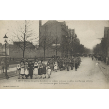 A Metz délivrée, des petites Lorraines, en costume national, précèdent une Musique militaire, en marchant au pas à la Française.