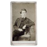 Portrait de Paul Bouget en costume, assis. 