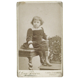 Petite fille assise au bord d'une table. 