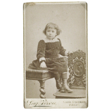 Petite fille assise au bord d'une table.