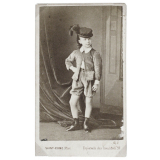 Fillette en habit de garçon et chapeau à plume. 