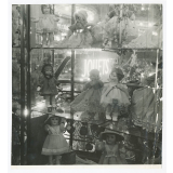 Vitrine d'un magasin de jouets contenant des poupées. 