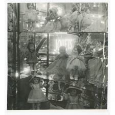 Vitrine d'un magasin de jouets contenant des poupées. 