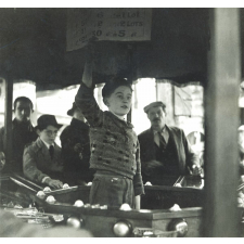 Enfant tenant un stand lors d'une fête foraine.