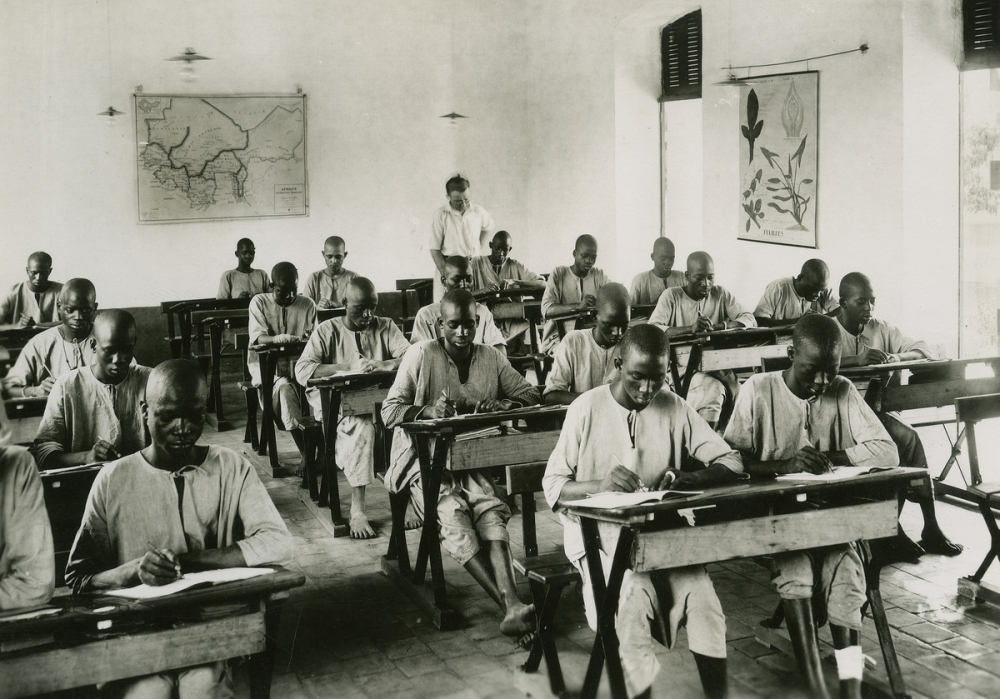 Etudiants africains composant dans une salle de classe avec un enseignant européen