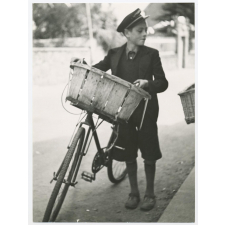Jeune garçon en uniforme assurant une tournée à vélo. 