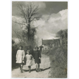 Trois fillettes en promenade en tenue d'écolières.