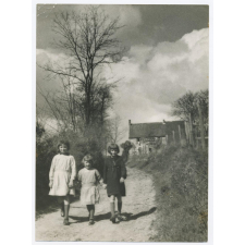 Trois fillettes en promenade en tenue d'écolières.
