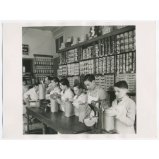 Epicerie. L'ensachage, le pesage, le paquetage du café et la fermeture des sachets par agrafe. Ecole d'alimentation 16 rue de (...) Atelier-école.