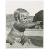 Enfant jouant au ballon sur la plage. 