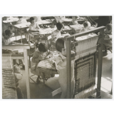 Fillette travaillant avec un métier à tisser en classe dans le cadre d'un atelier de couture. 
