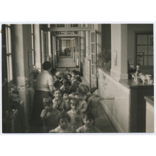 Enfants alignés dans un couloir d'école maternelle.