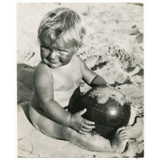 Enfant jouant au ballon sur la plage.