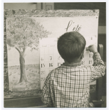Garçon remplissant le calendrier de la classe. 