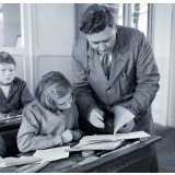 Ecole primaire. L'instituteur vérifie le cahier d'une élève.