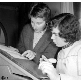 Collège d'enseignement technique pour jeunes filles. Le professeur de sténodactylographie conseille une élève pour graver un stencil.