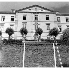 Lycée de Coutances : la façade sur les jardins. Trois élèves effectuent des exercices physiques.