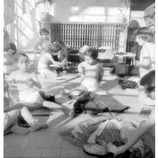 Ecole de plein air : jeux et lecture à même le sol : les élèves sont en petite tenue