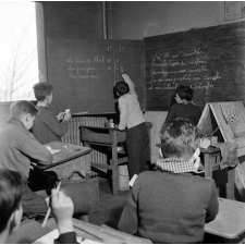 Méthode Freinet : l'apprentissage de l'imprimerie et la réalisation d'un journal scolaire. Les élèves écrivent des textes au tableau noir.