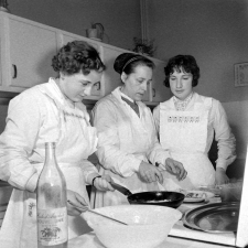 Collège d'enseignement technique pour jeunes filles. Le cours de cuisine. La fabrication d'un plat, sous la surveillance du professeur.