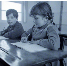 Ecole primaire. Une élève écrit mots et syllabes sur son cahier.