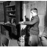 Méthode Freinet : l'apprentissage de l'imprimerie et la réalisation d'un journal scolaire. Un élève écrit un texte sur une ardoise.