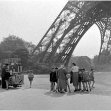 Méthode Freinet, école primaire de la Seine, classe promenade : les élèves sont au pied de la Tour Eiffel, partagés entre leur maîtresse et le marchand de glaces.