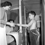 Service de santé scolaire et universitaire : dépistage de la tuberculose pour un enfant. Chaque élève est porteur de sa fiche qu'il présente à l'assistante à l'entrée du camion avant de se placer devant l'écran.