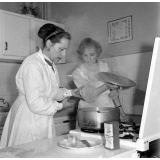 Collège d'enseignement technique pour jeunes filles. Le cours de cuisine. Le professeur encadre une élève.