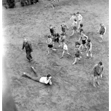 Pratique du sport sur un stade parisien : les élèves, sous la surveillance du professeur, effectuent des exercices.