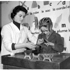 Centre de réadaptation fonctionnelle : un élève procède à des assemblages (la rééducation des mains et des doigts). En arrière-plan, apprentissage de la lecture.