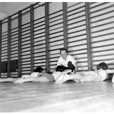 Service de la jeunesse et des sports : la rééducation neuro-motrice. Des jeunes filles pratiquent des exercices de musculation dorsale.