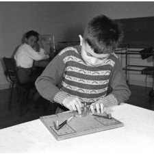 Centre de réadaptation fonctionnelle : un élève procède à des exercices d'ergothérapie des fléchisseurs des doigts.