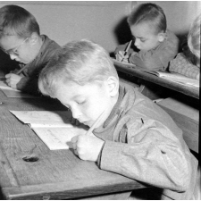 Ecole primaire de plein air : un garçon rédige un texte