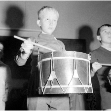 Enseignement musical : un élève de maternelle joue du tambour.
