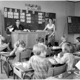 Ecole primaire, Nancy : l'inspecteur et l'institutrice sont au bureau, deux élèves présentent des travaux.