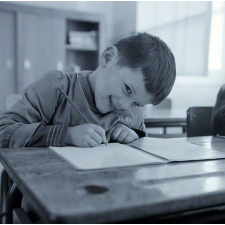 Ecole primaire. Un élève écrit lettres et syllabes.