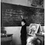 Méthode Freinet : l'apprentissage de l'imprimerie et la réalisation d'un journal scolaire. Un élève écrit un texte au tableau noir.