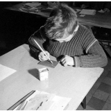 Méthode Freinet : l'apprentissage de l'imprimerie et la réalisation d'un journal scolaire. Un élève réalise un dessin sur une plaque.