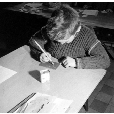 Méthode Freinet : l'apprentissage de l'imprimerie et la réalisation d'un journal scolaire. Un élève réalise un dessin sur une plaque.