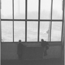 Méthode Freinet, classe promenade : paysage dans le brouillard. Vue, à travers une baie, sur un alignement de voitures (Panhard) et une cheminée d'usine.