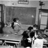 Méthode Freinet : l'apprentissage de l'imprimerie et la réalisation d'un journal scolaire. Une élève lit un texte devant ses camarades.