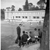 Centre d'éducation surveillée : la détente. Des jeunes sur un banc, d'autres disputant un match de football.